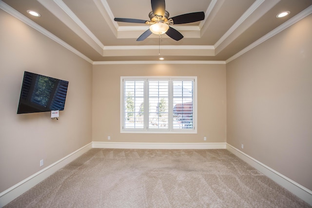 unfurnished room with light carpet, baseboards, ornamental molding, and a raised ceiling