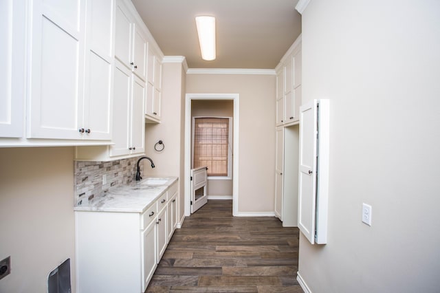 kitchen with dark wood finished floors, a sink, white cabinetry, and decorative backsplash