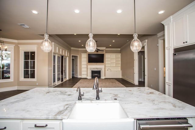 kitchen with decorative light fixtures, stainless steel appliances, visible vents, open floor plan, and a sink