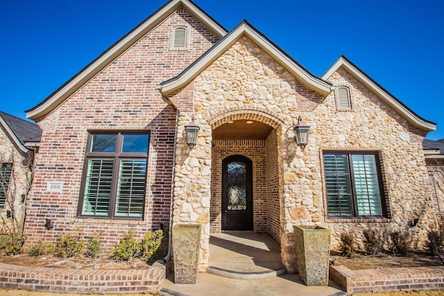 view of front facade featuring stone siding and brick siding