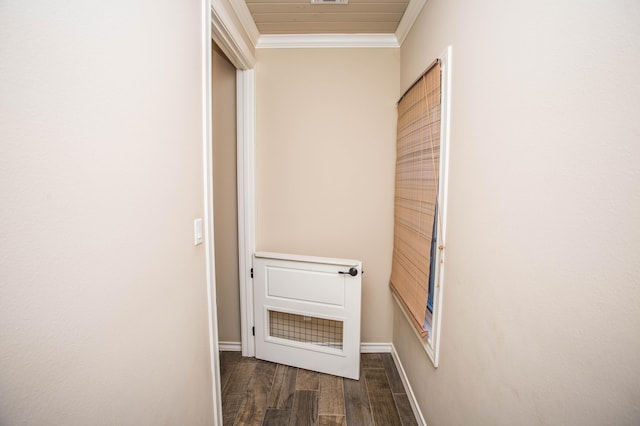 hallway with ornamental molding, dark wood-style flooring, and baseboards