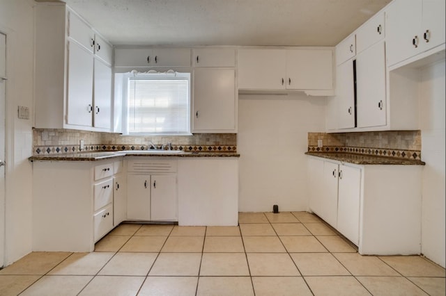 kitchen with sink, decorative backsplash, white cabinets, and light tile patterned flooring