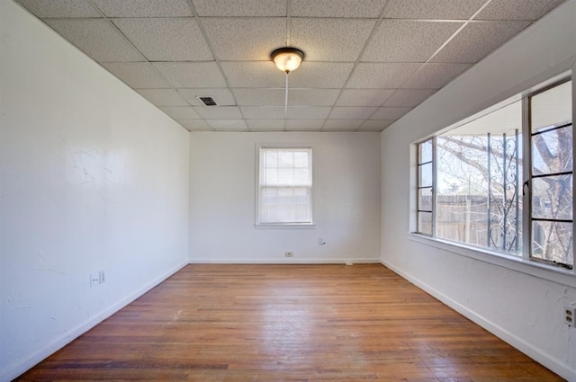 spare room featuring a paneled ceiling and wood-type flooring