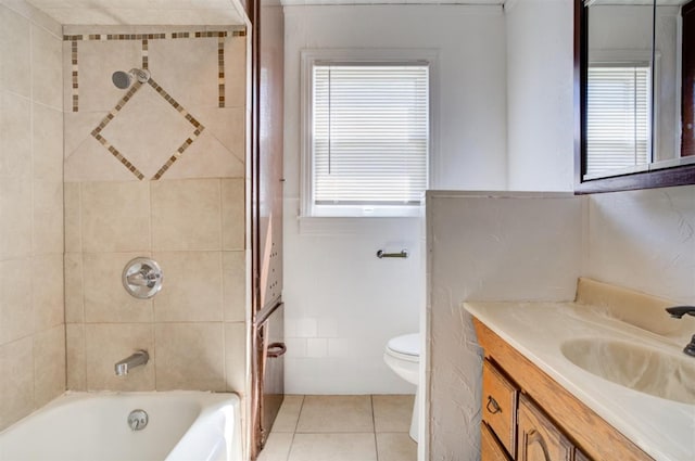 full bathroom with tile walls, tiled shower / bath combo, vanity, tile patterned floors, and toilet