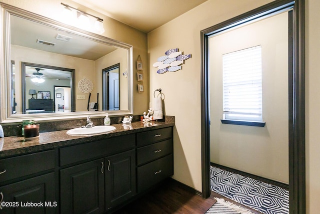 10018 Ave X, Lubbock, TX 79423 - bathroom featuring vanity, a ceiling fan, and wood finished floors
