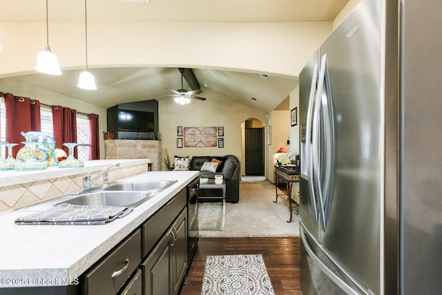 10018 Ave X, Lubbock, TX 79423 - kitchen with stainless steel fridge, arched walkways, light countertops, and dark wood-type flooring
