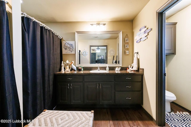 10018 Ave X, Lubbock, TX 79423 - full bathroom featuring wood finished floors, toilet, and vanity