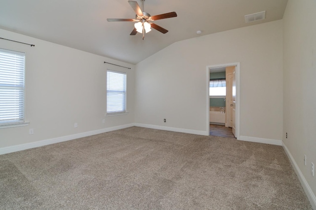 carpeted empty room with vaulted ceiling and ceiling fan