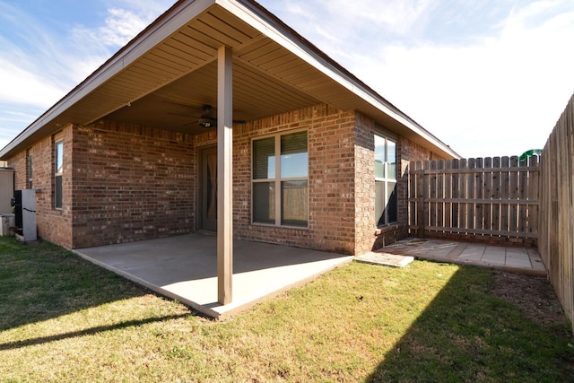 exterior space featuring a patio, ceiling fan, and a lawn