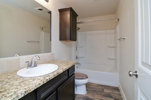 full bathroom featuring vanity, hardwood / wood-style floors, shower / tub combination, and toilet