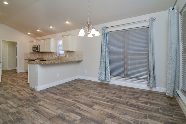 kitchen featuring pendant lighting, white cabinetry, backsplash, dark hardwood / wood-style flooring, and kitchen peninsula