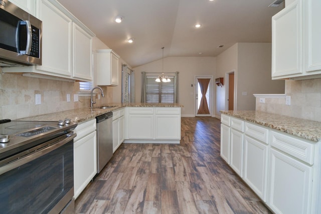 kitchen featuring stainless steel appliances, sink, pendant lighting, and white cabinets