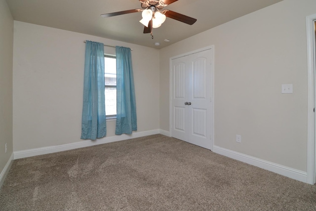 carpeted spare room featuring ceiling fan