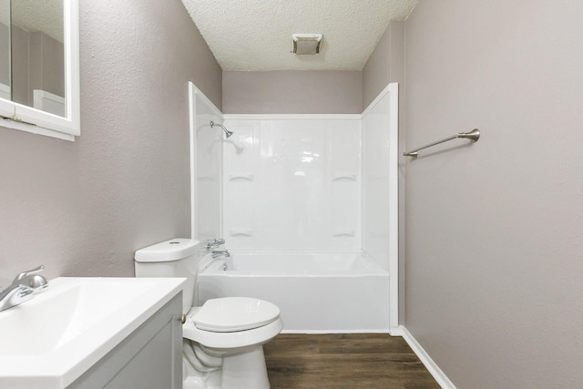 full bathroom featuring hardwood / wood-style floors, vanity, toilet, bathing tub / shower combination, and a textured ceiling