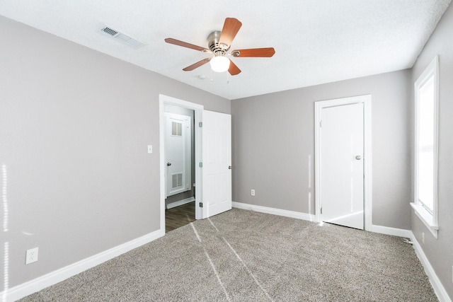 unfurnished bedroom with ceiling fan, carpet flooring, and multiple windows