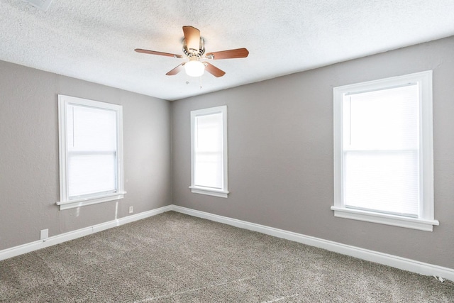 carpeted empty room with ceiling fan and a textured ceiling