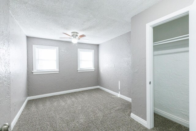 unfurnished bedroom with ceiling fan, carpet flooring, a closet, and a textured ceiling