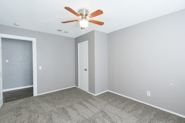 unfurnished bedroom featuring ceiling fan and dark colored carpet