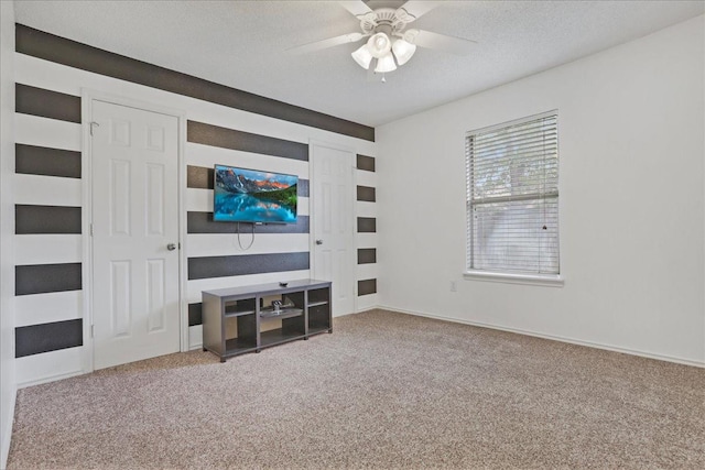 living room with ceiling fan, a textured ceiling, and carpet flooring