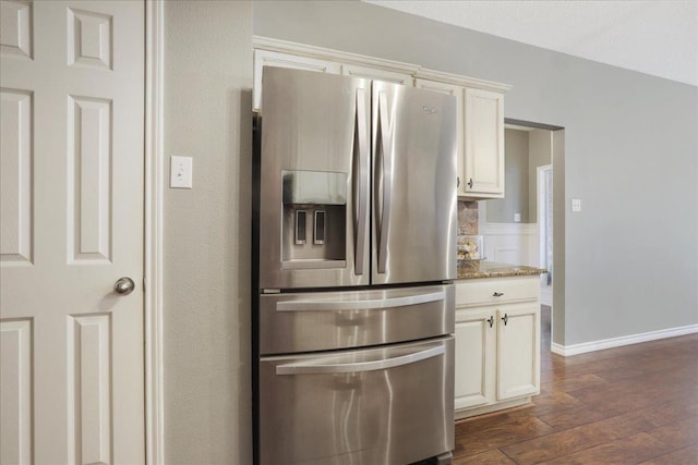 kitchen featuring white cabinetry, light stone countertops, dark wood-type flooring, and stainless steel fridge