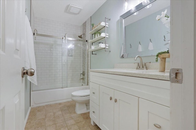 full bathroom featuring vanity, shower / bath combination with glass door, and toilet