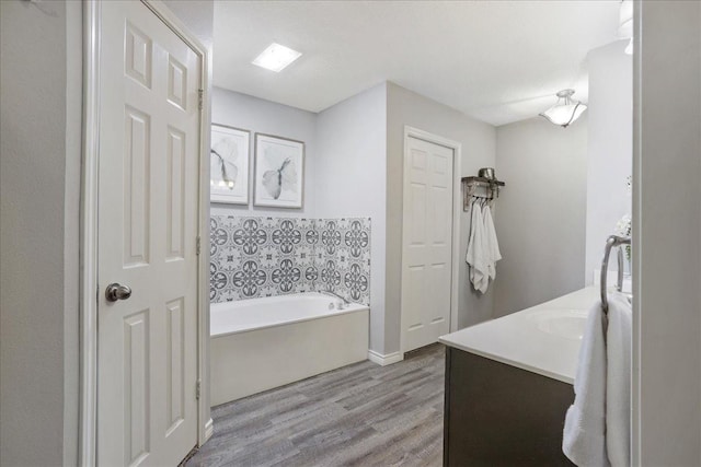 bathroom with vanity, a tub to relax in, and hardwood / wood-style flooring