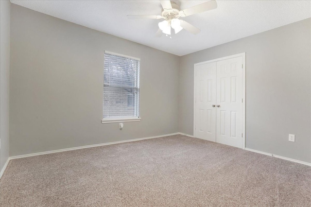 unfurnished bedroom featuring carpet floors, a closet, and ceiling fan