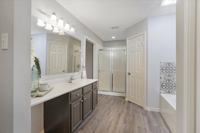 bathroom featuring vanity, separate shower and tub, and hardwood / wood-style floors