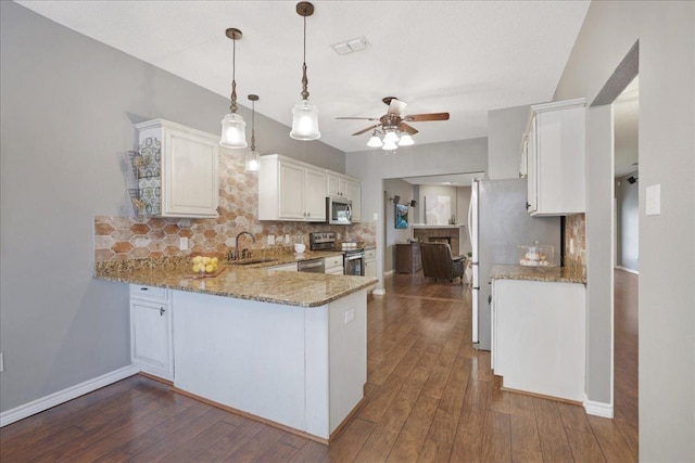 kitchen with sink, kitchen peninsula, white cabinets, and appliances with stainless steel finishes