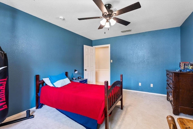 bedroom with ceiling fan, carpet, and a textured ceiling