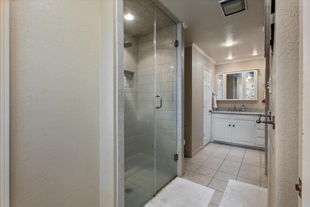 bathroom featuring tile patterned floors, ornamental molding, an enclosed shower, and vanity