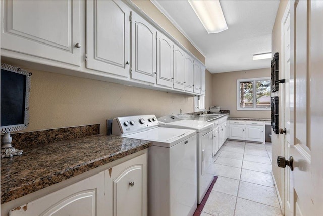 washroom featuring independent washer and dryer, cabinets, sink, and light tile patterned floors