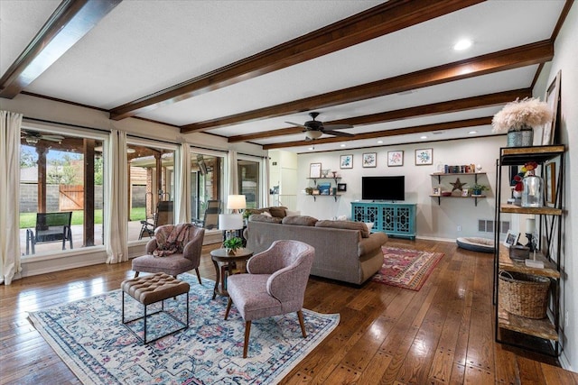 living room featuring dark wood-type flooring, ceiling fan, and beamed ceiling