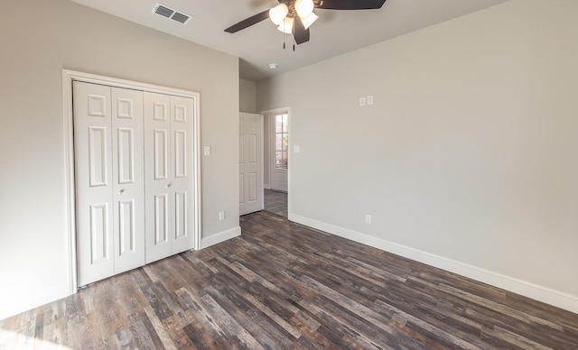 unfurnished bedroom with dark hardwood / wood-style floors, ceiling fan, and a closet