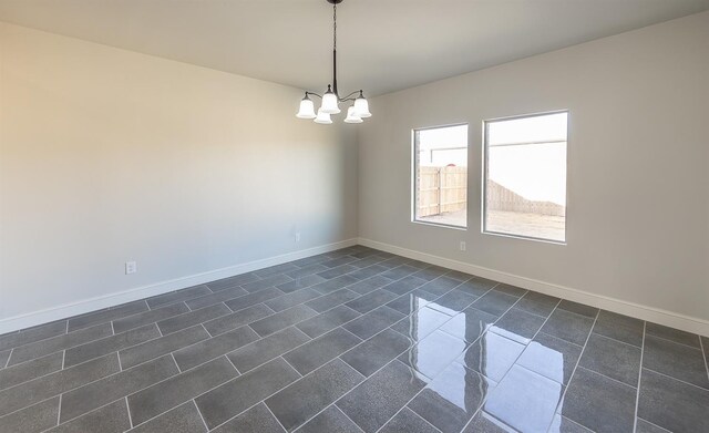 tiled empty room with a chandelier