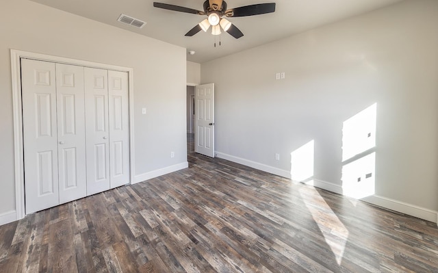 unfurnished bedroom featuring dark wood-type flooring, ceiling fan, and a closet