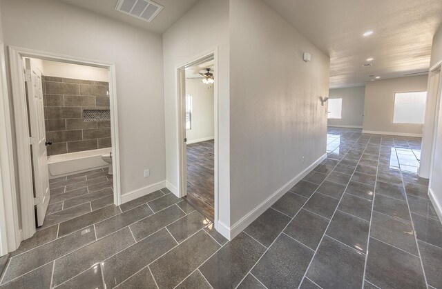 hall with dark tile patterned flooring