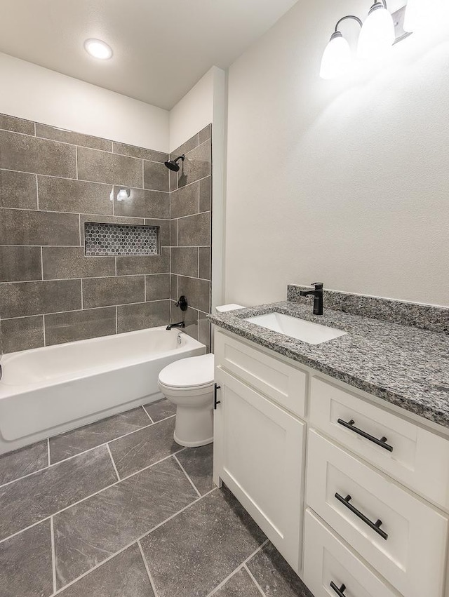 full bathroom with vanity, tiled shower / bath combo, and toilet