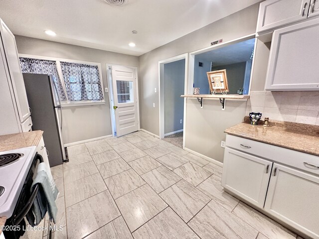 2802 54th St, Lubbock, TX 79413 - kitchen featuring range with electric stovetop, freestanding refrigerator, baseboards, recessed lighting, and light countertops