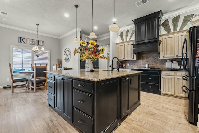 10801 Richmond Ave, Lubbock, TX 79424 - kitchen with tasteful backsplash, a center island with sink, a sink, light wood finished floors, and visible vents