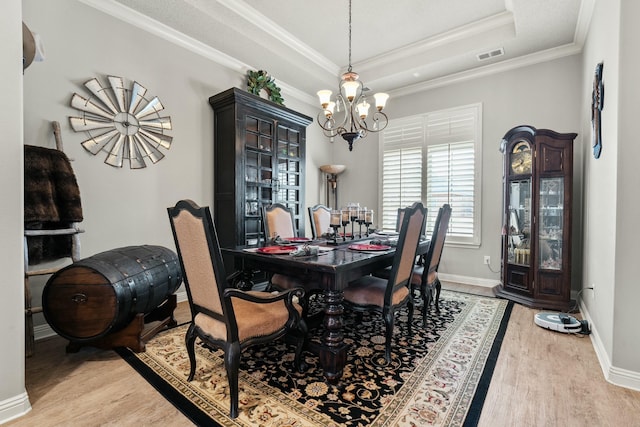 10801 Richmond Ave, Lubbock, TX 79424 - dining room with visible vents, a tray ceiling, light wood-style flooring, and a notable chandelier