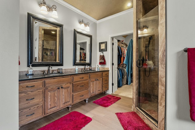 10801 Richmond Ave, Lubbock, TX 79424 - full bath featuring ornamental molding, a shower stall, a sink, double vanity, and wood finished floors