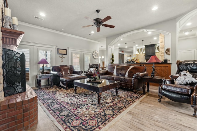 10801 Richmond Ave, Lubbock, TX 79424 - living room with visible vents, light wood finished floors, ceiling fan, ornamental molding, and arched walkways