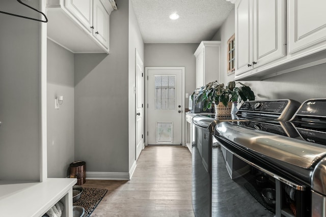 10801 Richmond Ave, Lubbock, TX 79424 - laundry area featuring light wood-type flooring, independent washer and dryer, baseboards, a textured ceiling, and cabinet space