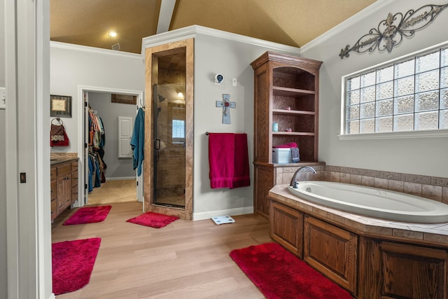 10801 Richmond Ave, Lubbock, TX 79424 - bathroom with a stall shower, a garden tub, wood finished floors, a walk in closet, and ornamental molding
