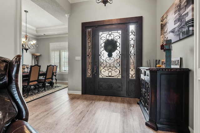 10801 Richmond Ave, Lubbock, TX 79424 - foyer featuring a notable chandelier, a raised ceiling, light wood finished floors, baseboards, and ornamental molding