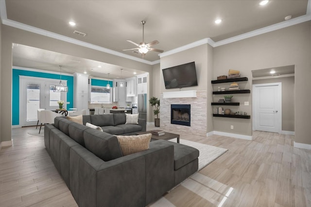 living room with crown molding, ceiling fan, a fireplace, and light hardwood / wood-style floors