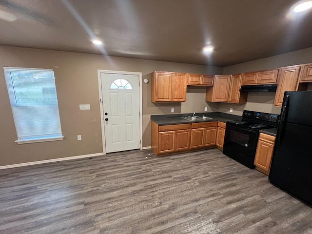 kitchen with plenty of natural light, dark hardwood / wood-style floors, sink, and black appliances