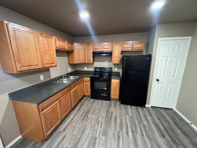 kitchen with sink, black appliances, and hardwood / wood-style floors