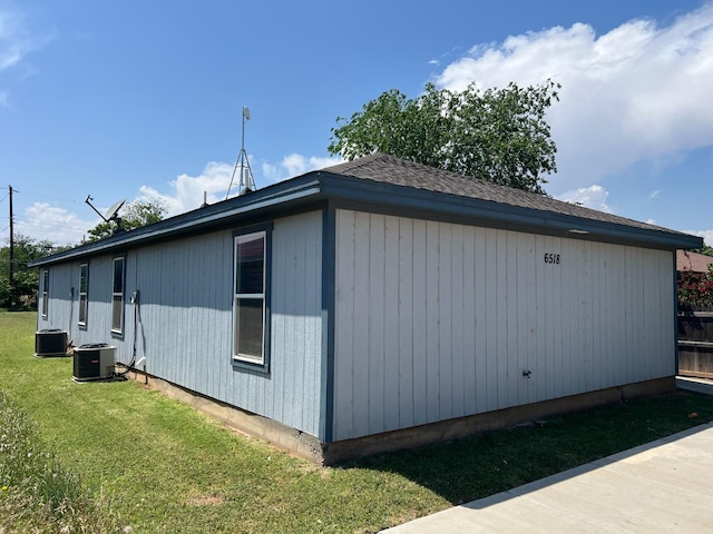 view of side of home with cooling unit and a yard